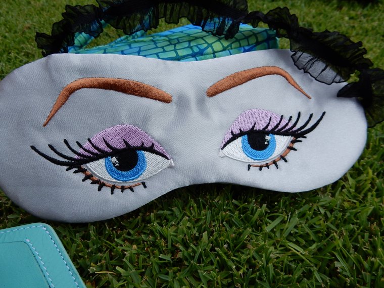 "I never sleep on planes" eye mask.  Anita Goodesign embroidery.  Gray poly satin fabric, black lace elastic.